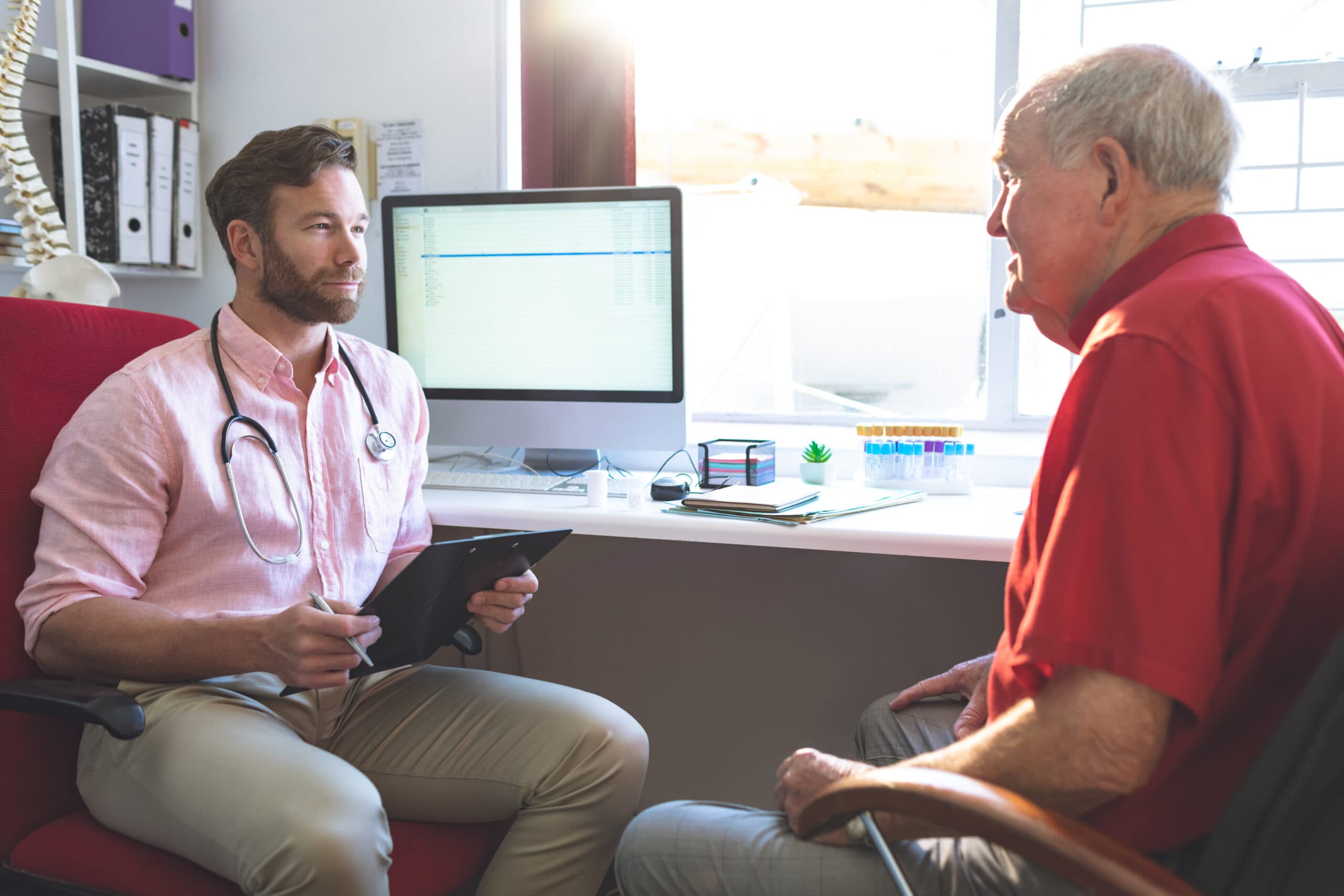 Physician reviewing patient health history during chronic illness exam
