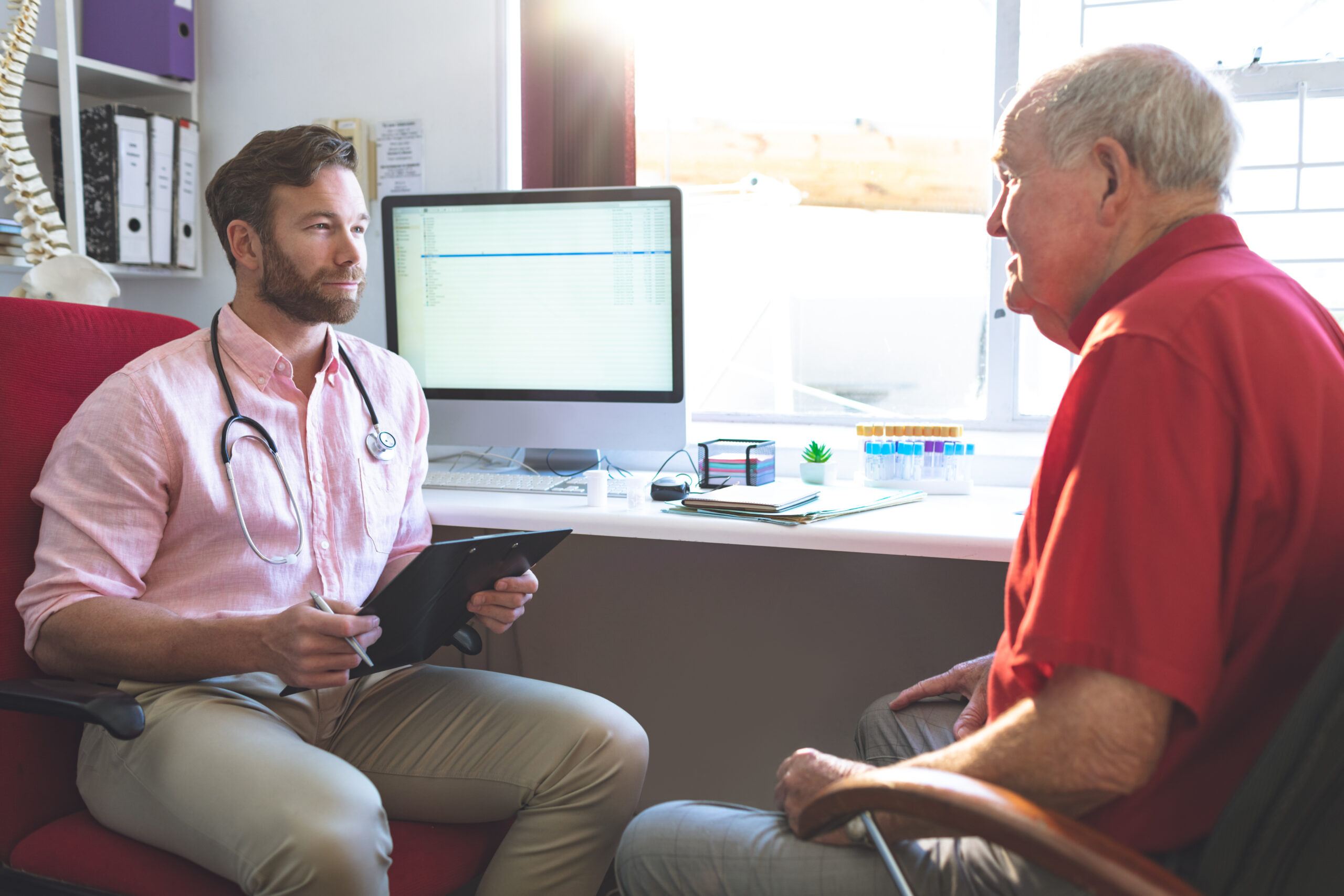 Physician reviewing patient health history during chronic illness exam